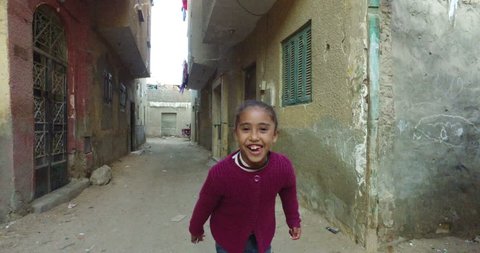 CAIRO, EGYPT - FEBRUARY 03, 2016: Beautiful local girl running down the street in Giza