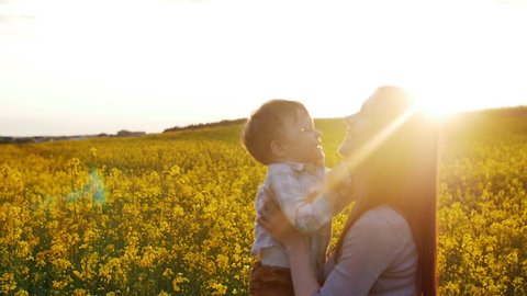 mother plays with son at field at sunset. Slow mo
