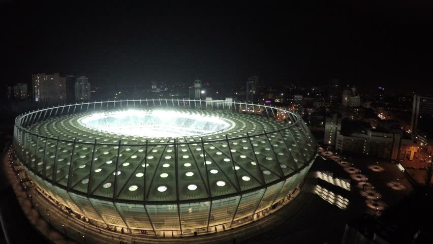 KYIV, UKRAINE - CIRCA JUNE 2016: Aerial view of Olimpiyskiy stadium. Amazing architecture of modern sports arena illuminated at night, aerial shot