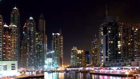 Dubai Jumeira Marina life Night view time-lapse video 4k. Skyscrapers modern buildings reflect in water Travel tourism Real Estate business in United Arab Emirates time lapse.