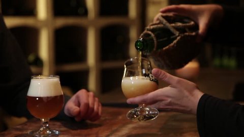 Pouring Beer From Bottle, Gueuze Belgian Beer. Gueuze is a type of lambic, a Belgian beer. It is made by blending young lambics, which is then bottled for a second fermentation.