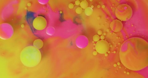 Color drops floating in oil and water over a colorful underground with oil painting effect.  Stock Video