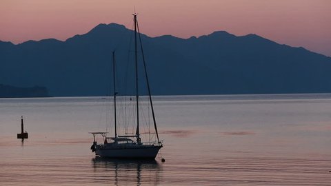 Sailing boat and sunrise behind the mountains in Marmaris, Turunc bay.