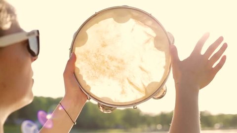 Musical instrument tambourine or pandeiro on a background of the sky at sunset
