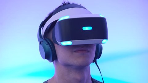MOSCOW, RUSSIA - JUNE 19, 2016: A young man uses VR-headset display and headphones for virtual reality game on the Geek Picnic - festival about technology, art and science.