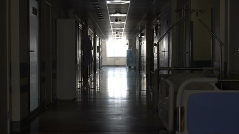 Dark long corridor with a bed in the hospital
