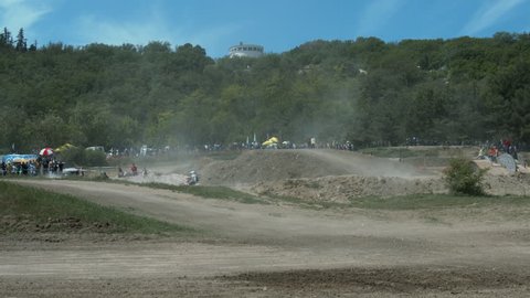 Motocrossers Perform Jumping From the Springboard During a Motocross Race Off-Road
