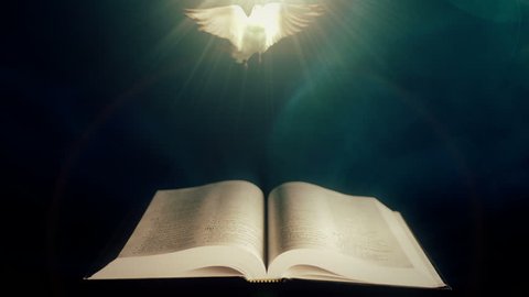 Holy Bible with Dove of Peace illuminated by a beam of light.