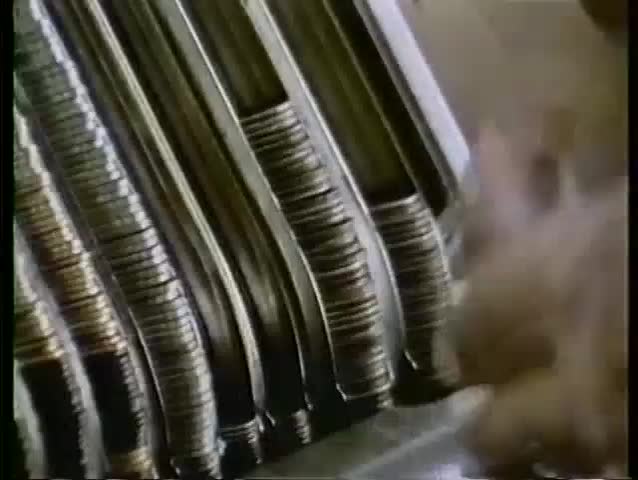 Close-up of person stacking coins in coin holder, 1970s