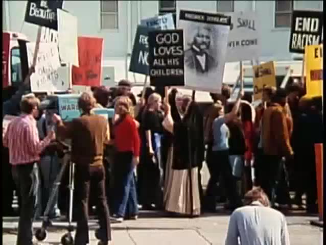 Demonstrators holding signs during protest, 1970s