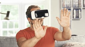 4K - Ultra HD: Young man wearing virtual reality googles / VR Glasses. His living room transforms into VR space -  with special visual effects