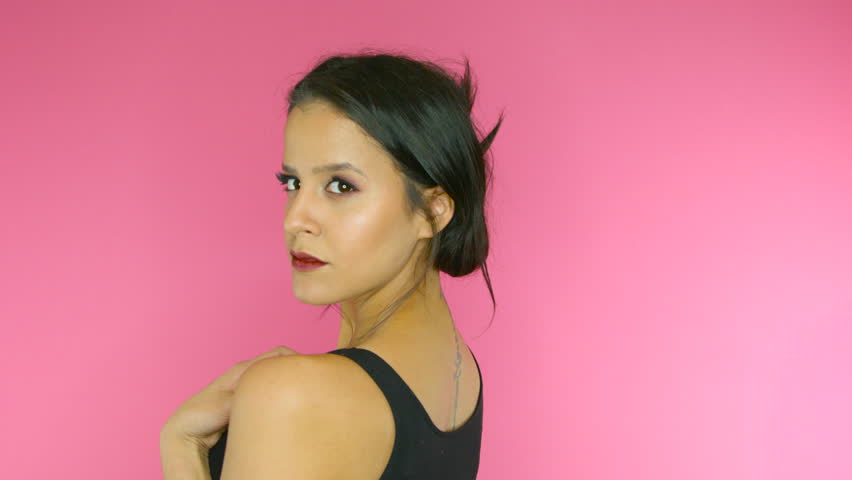Beautiful girl posing and being happy on bright pink background