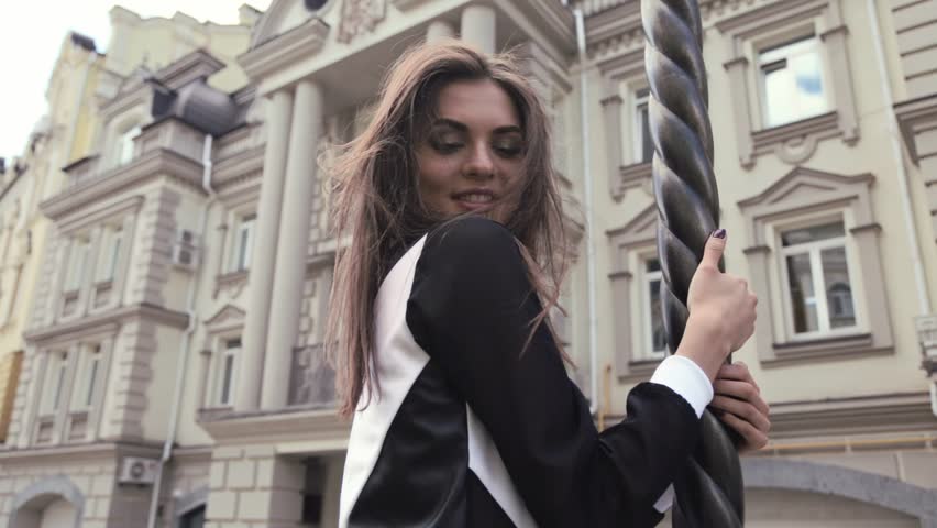 Beautiful girl fashion model posing on the street day long dark hair wearing a black and white fashionable dress on a background of modern architecture building classical European style town | Shutterstock HD Video #17528752