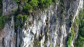 Aerial flying footage ascending up a cliff face of a mountain in Krabi, Thailand