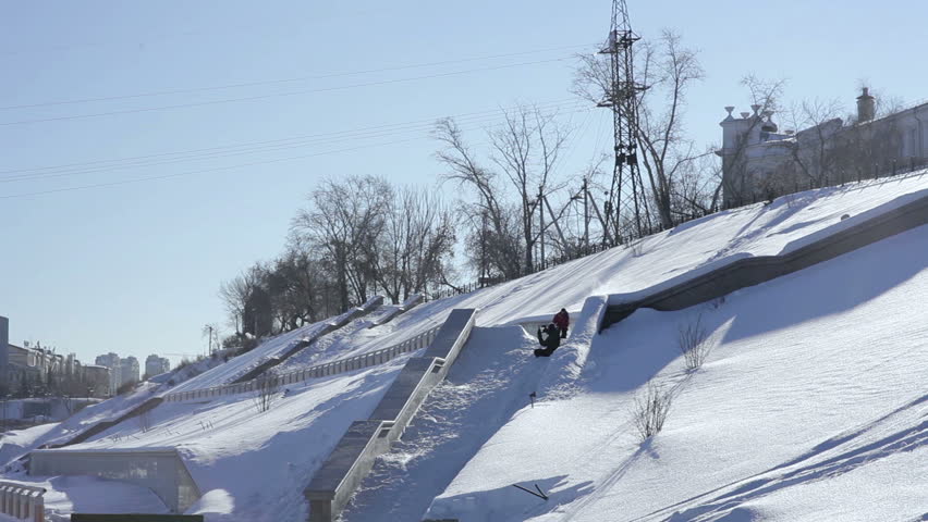 Skier doing a slide trick on a ledge in the street