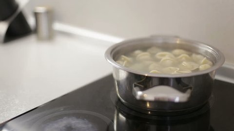 Russian national food dumplings simmer in a saucepan