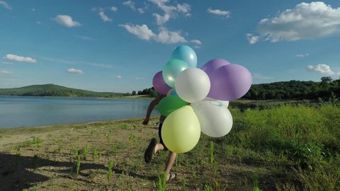 Boys celebrating summer vacation with colorful balloons at the lake.
happy Kids having Fun with Balloons.