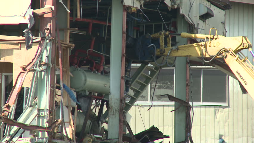 KESENNUMA, JAPAN - APRIL 1: A crane works on a destroyed building in the