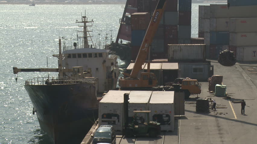 HONG KONG - CIRCA JUNE 2010: A crane loads cargo onto a ship in Hong Kong circa