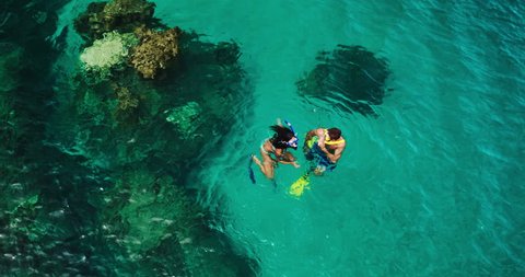 Aerial view young couple snorkeling in tropical blue ocean