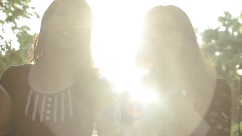 Cute girls having fun and laughing walks with sunlight