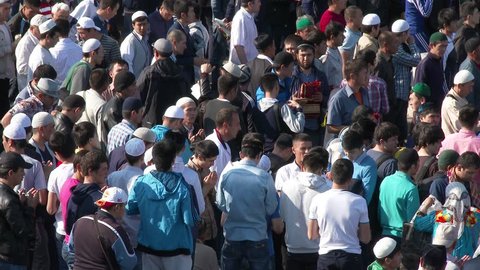 MOSCOW, RUSSIA - JULY 17, 2015: Muslims prayers on celebration of Eid al-Fitr (Uraza-Bairam). Crowd of migrants from Central Asia in Moscow, Russia
