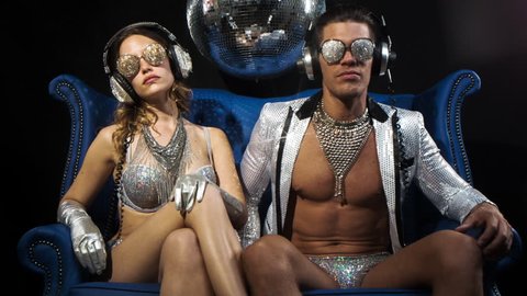 Two silver sexy disco characters. a male and female in sparkling silver costumes, great for fashion, style and events