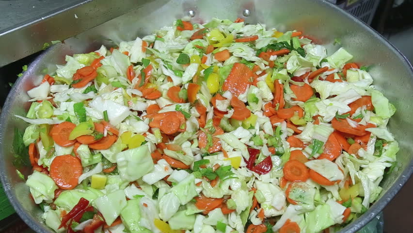 Mixing salads with hands in an industrial kitchen