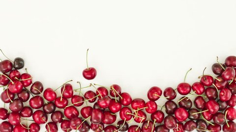 Falling down of fresh cherries on white background. Top view. stop motion animation, 4K: film stockowy
