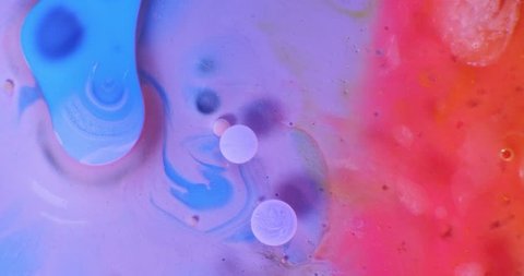 Color drops floating in oil and water over a colorful underground with oil painting effect. Shot on RED: stockvideo