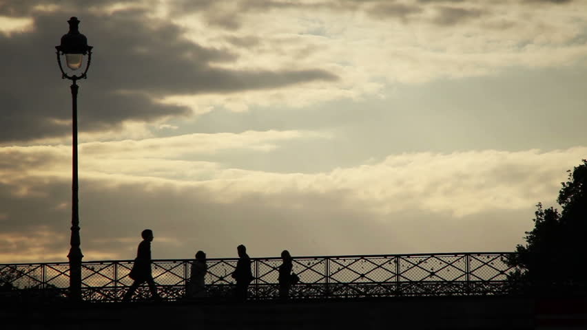 People walk along Ponts des Arts bridge which is covered in love locks