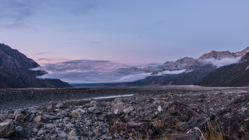 Time lapse of mist moving into the Tasman Valley (South Island, new Zealand) during sunrise as the rays of sun hit the peaks, and the mist covers the landscape.