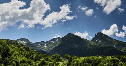 Mountains Timelaps of Krasnodar region, Krasnaya Polyana, red glade, Sochi, Russia, a clear sunny weather, clouds float on the Green Mountains, leaving under itself shadows, zoom effect