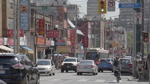 TORONTO, CANADA - JUNE 2016: Chinatown in downtown Toronto during the day. 4K UHD. Busy streets, cars, streetcars, buses.