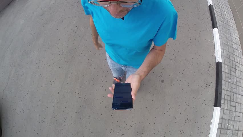 Man riding on roller skates with touch phone near cars with camera on head