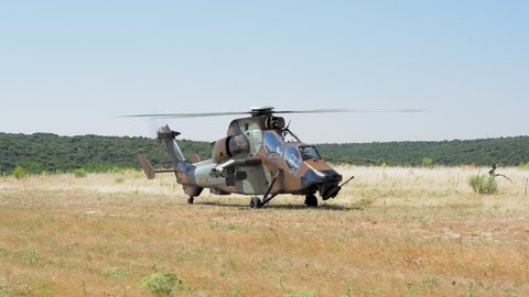 MADRID, SPAIN - JUNE 23, 2016: A fully armed Spanish Army Eurocopter Tiger helicopter takes off, short moves and lands on open field (part of units 50th anniversary). With ambient sound. ProRes HQ