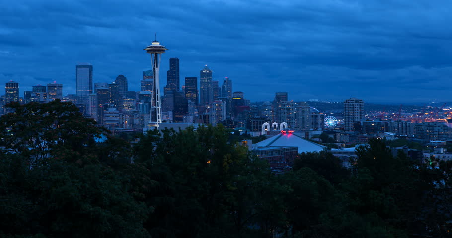 Seattle, Washington, USA - illuminated skyline of Seattle with Space needle, harbor and Elliott Bay - view from Kerry Park at sunset with clouds - Timelapse with motion and zoom in 