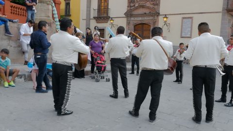 SAN MIGUEL DE ALLENDE, MEXCIO - CIRCA MAY 2016 - A large group of mariachi band members play for tourists steadicam shot with audio.