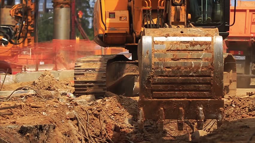 Yellow excavator at building site.