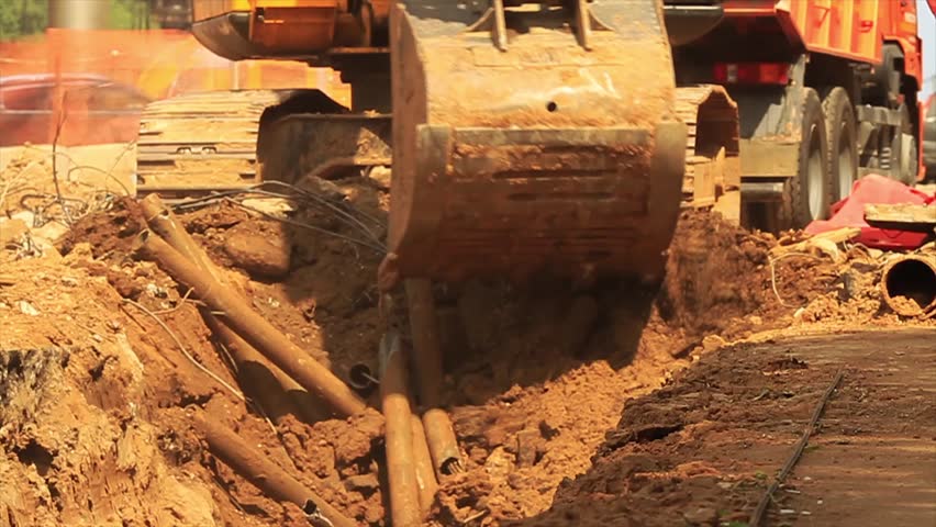 Yellow excavator at building site.