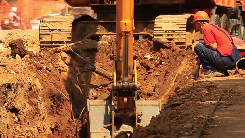 Yellow excavator at building site.
