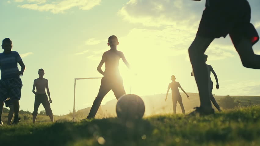 Simple poor farmer boys playing football on the background of a bright sunset in summer hot day. Slow motion. Royalty-Free Stock Footage #17646238