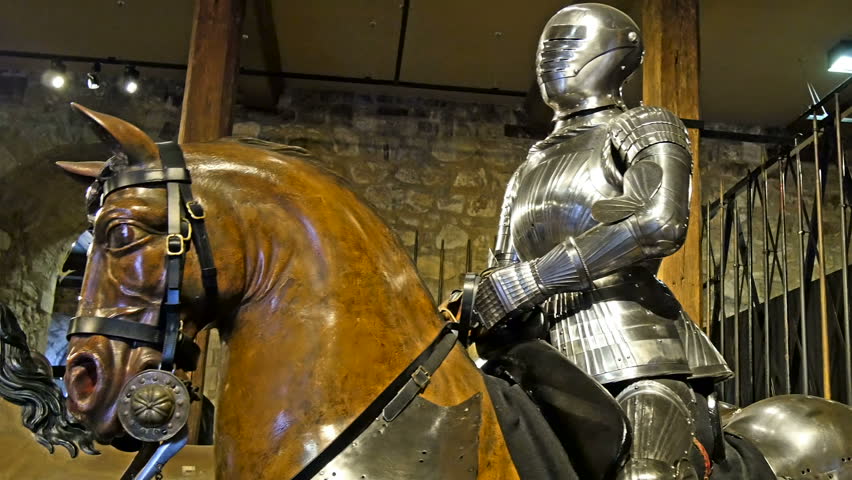 A knight in a metal armor riding a horse display inside the castle museum in London