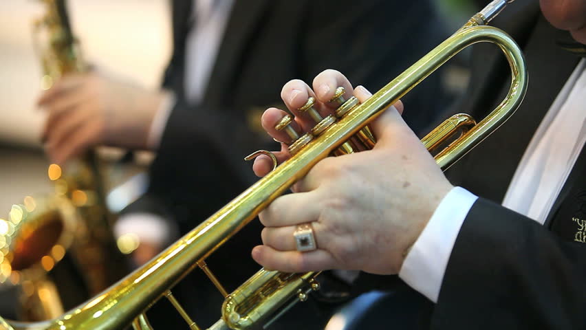 man playing on golden trumpet