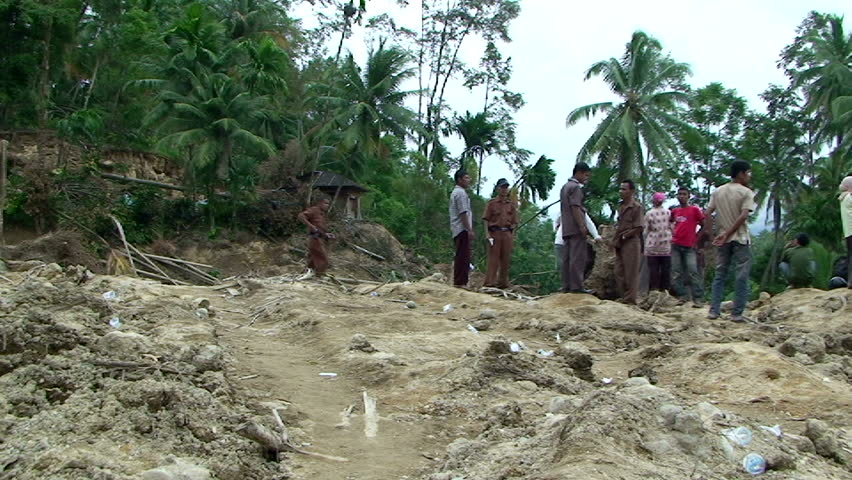 PADANG, INDONESIA - CIRCA OCTOBER 2009: Survivors survey landslide damage in