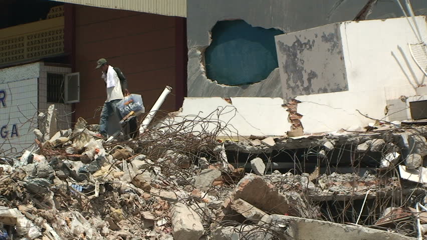 PADANG, INDONESIA - CIRCA OCTOBER 2009: Man clambers over debris in aftermath of
