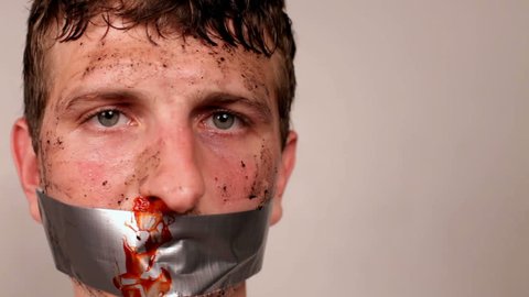 Prisoner or an abducted male with bloody nose and duct tape on his mouth.