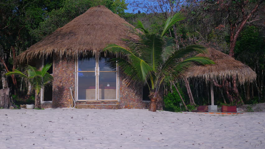 Lovely bungalow with palm trees on a white sand beach (close up)