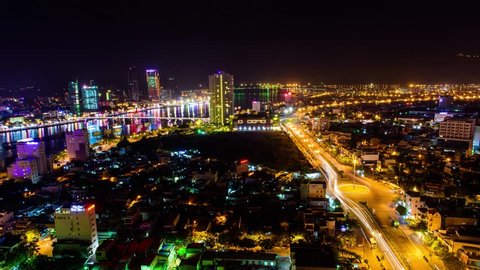 Timelapse city by night. Busy traffic on the roads and shimmering beauty of Da Nang city by night. Skyscrapers, cruises on Han River and planes,...