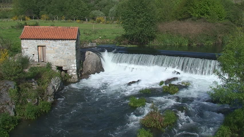 Small waterfall in river with pretty house made in rock
